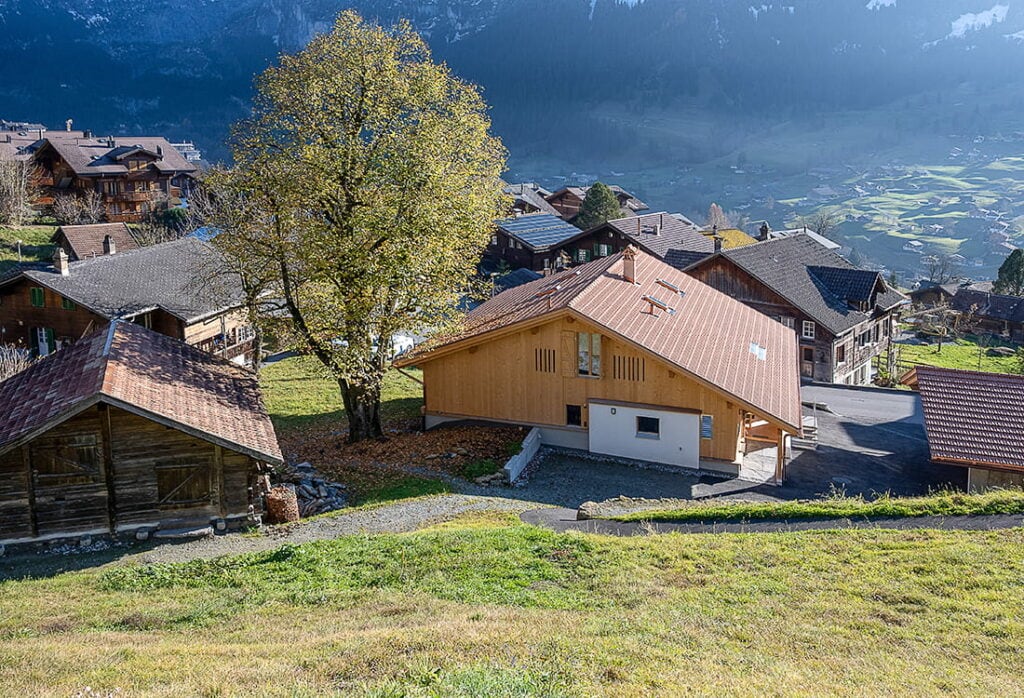 Saniertes ehemaliges Bauernhaus in Grindelwald von der Rückseite, mit Ausblick ins Tal